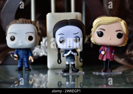 Funko Pop Actionfiguren des Serienmörders Michael Myers von Halloween, Wednesday Addams und Sabrina Spellman. Säulen, Reflektionsboden, weiße Tür. Stockfoto