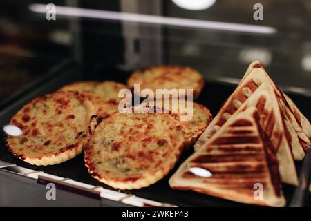 Frisch gebackene Quiches mit Käse und Brotumschlägen am Ladentisch Stockfoto