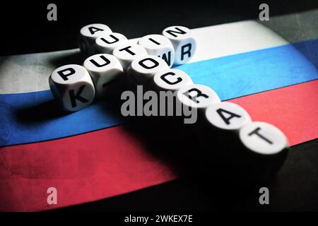 Buchstabenwürfel bilden die Wörter Putin und Autocrat (engl.) In Cross Form Auf Russischer Flagge Stockfoto