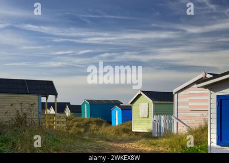 Hunstanton, Norfolk, Großbritannien – farbenfrohe Strandhütten in den Sanddünen von Old Hunstanton, die an einem sonnigen Tag dargestellt werden Stockfoto