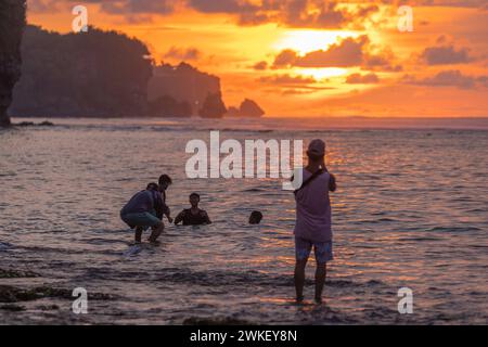 Menschen am Bingin Beach bei Sonnenuntergang, Uluwatu, Bali Island, Indonesien Stockfoto