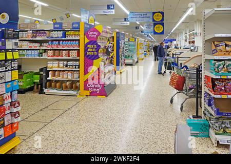 Supermarkt Einkaufsgang Innenansicht von Käufern in Regalen, in denen Lebensmittelwaren im Terrazzo-Stockwerk des Einzelhandelsgeschäfts Essex England Großbritannien gezeigt werden Stockfoto