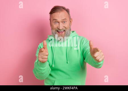 Foto-Porträt von gutaussehendem Senior man Point Sie aufgeregt hey tragen trendiges grünes Kleid isoliert auf rosa Hintergrund Stockfoto