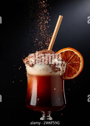 Schokoladencocktail mit Schlagsahne. Süßes Getränk mit Schokoladenchips bestreut und mit einer getrockneten Orangenscheibe garniert. Stockfoto