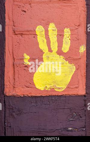 Gelber Handabdruck auf einer alten Hausfassade. Stockfoto