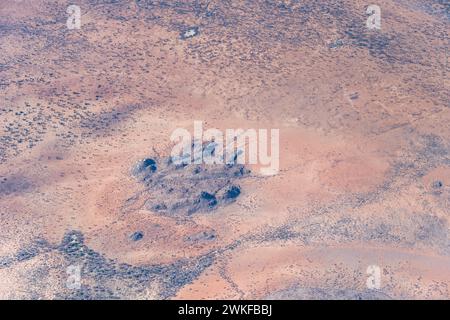 Luftlandcape mit Basalt-Felsblöcken in der Wüste, aufgenommen aus einem Segelflugzeug in hellem Licht des späten Frühlings in der Nähe von Kamkam, Namibia, Afrika Stockfoto