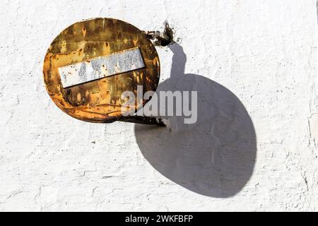 Alt und rostig, kein Zufahrtszeichen an weißer Fassade in Andalusien, Spanien Stockfoto