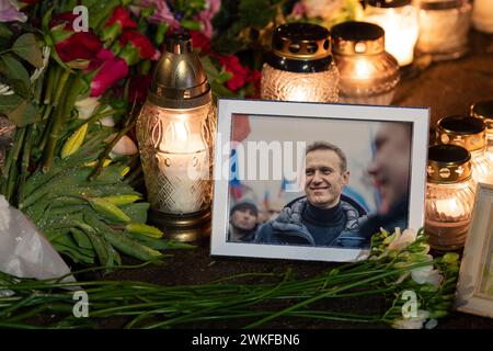 Blumen und Kerzen wurden zur spontanen Gedenkfeier für den russischen Oppositionsführer Alexej Nawalny gelegt, mit einem lächelnden Porträt, das von Schnee und Regentropfen nass war Stockfoto