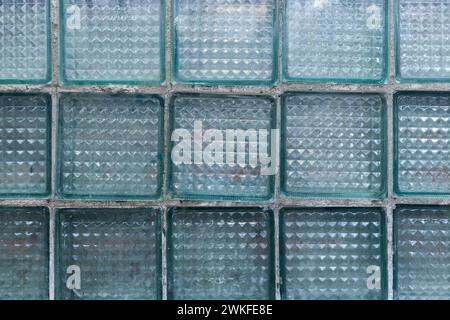 Raue transparente Wand aus Glasblöcken, Hintergrundfotostruktur für industrielle Architektur Stockfoto