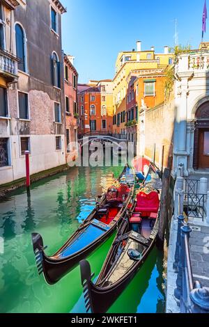 Traditionelle Gondeln und Brücke auf dem schmalen Kanal in Venedig, Italien. Architektur und Wahrzeichen von Venedig. Stockfoto