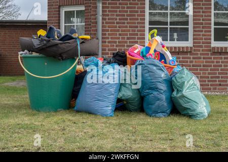 Vor einem Haus mit Müllsäcken, Regenfässern und Spielzeug Stockfoto