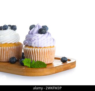 Holzbrett mit leckeren Cupcakes mit Heidelbeeren auf weißem Hintergrund Stockfoto