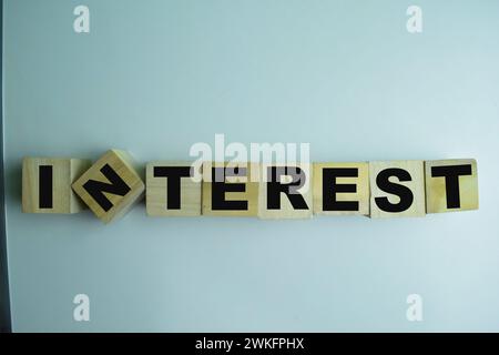 Konzept der Holzwürfel mit dem Wort Interesse auf hölzernem Hintergrund. Stockfoto