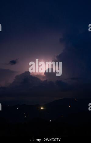 Ein abendliches Gewitter mit Blitz in den Karpaten, dem Dorf Dzembronya. Dramatische Wolken während eines Gewitters durchdringen das Licht Stockfoto