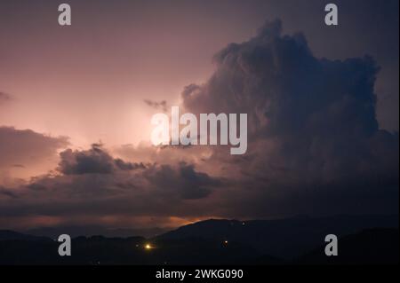 Ein abendliches Gewitter mit Blitz in den Karpaten, dem Dorf Dzembronya. Dramatische Wolken während eines Gewitters durchdringen das Licht Stockfoto