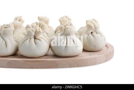 Holzbrett mit ungekochten Khinkali (Knödel) isoliert auf weiß. Georgische Küche Stockfoto