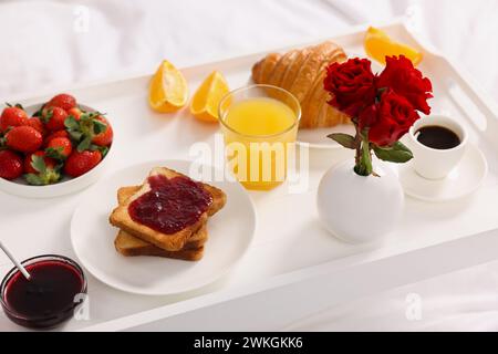 Tablett mit leckerem Frühstück auf dem Bett, Nahaufnahme Stockfoto