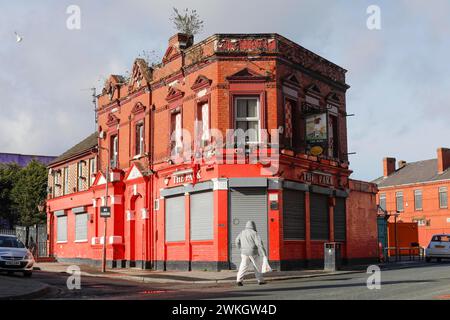 Ein Mann läuft an einem Haus in der Nähe des Fußballstadions Anfield des Liverpool FC, 03/2019 vorbei Stockfoto