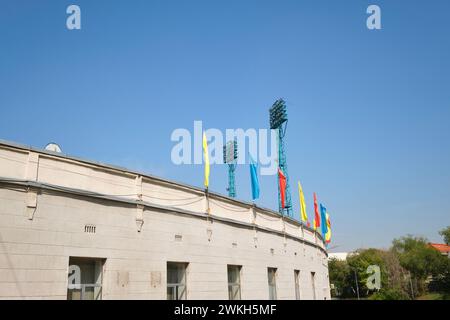 Ein Blick auf die bunten Fahnen, die fliegen, und die hohen Lichttürme. Im Central Football Stadion in Almaty, Kasachstan. Stockfoto