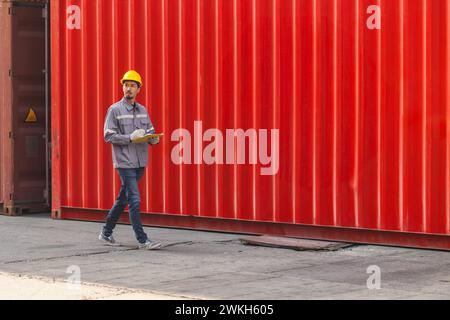Frachtcontainer-Werft arbeitende Mitarbeiter gehen Scheck auf der Suche nach Import Export Zoll Service Team Officer Stockfoto