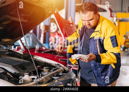 Mann, der den Motorölstand in der Werkstatt überprüft. Mechaniker arbeiten in der Werkstatt an einem Servicewagen Stockfoto
