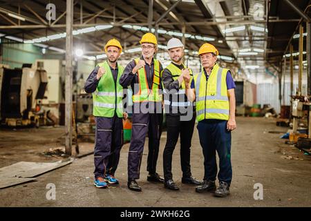 Ein männliches Ingenieurteam, das in der Schwerindustrie arbeitet, steht zusammen. Eine Gruppe professioneller Mitarbeiter arbeitet glücklich und selbstbewusst zusammen. Stockfoto