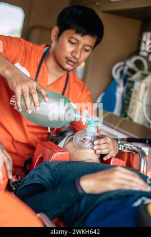 Rettungssanitäter-Notfallteam mit wiederverwendbarem manuellen Beatmungsgerät oder Ambu-Beutel zur Unterstützung der Atmung von Unfallpatienten in der mobilen Einheit des Krankenhausautos Stockfoto