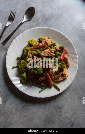 Blick von oben auf gebratenes Gemüse, serviert auf einem weißen Teller. Stockfoto