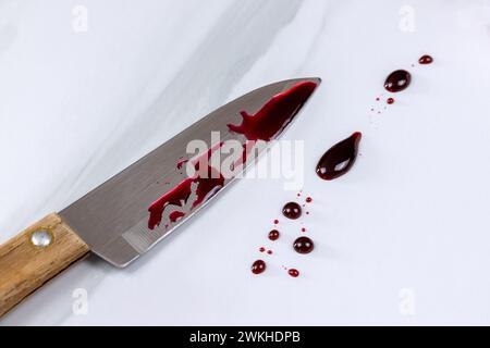 Blutiges Messer und Blutflecken auf einem Tisch Stockfoto