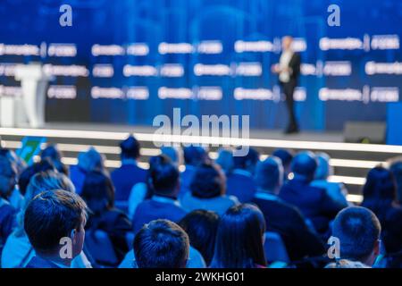 Das Publikum hört aufmerksam den Hauptredner auf einer Firmenveranstaltung zu. Unscharfer Konferenzhintergrund. Stockfoto