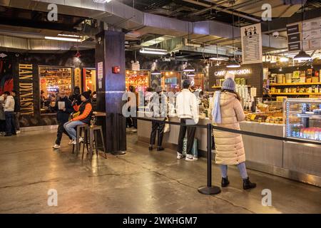 Ein lebhafter Outdoor-Markt voller Menschen, die Produkte durchsuchen Stockfoto