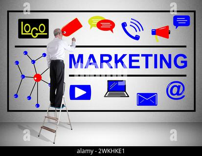 Mann auf einer Leiter, der Marketingkonzept an einer Wand zeichnet Stockfoto