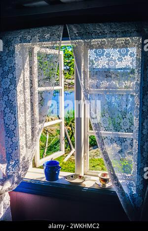 Offenes Fenster in einem alten Ferienhaus mit Seeblick im Sommer Stockfoto