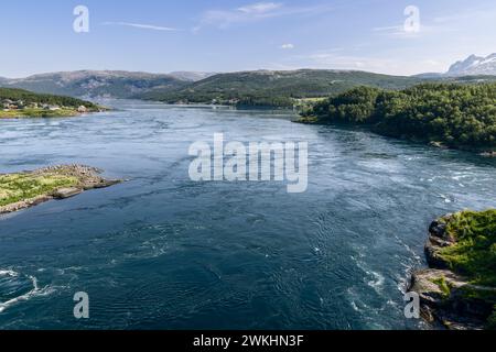 Die dynamische Saltstraumen-Flut, von oben erfasst, mit ihren mächtigen Whirlpools, die sich von der ruhigen nordischen Landschaft und den Wohngebieten abheben Stockfoto