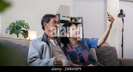 Glückliches altes Ehepaar ältere Menschen machen Selfie auf dem Handy, ältere Erwachsene Ehepartner, Frau und Mann lachen mit dem Telefon, machen Selbstporträt auf dem Smartphone Stockfoto