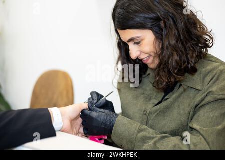 Maniküre, die die Nägel entfernt, poliert. Professionelle Maniküre-Behandlung im Schönheitssalon. Handhygiene und Pflege in der Schönheitsindustrie. Stockfoto