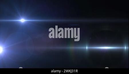 Bild eines Scheinwerfers mit Streulicht und Lichtstrahlen, die sich über einen dunklen Hintergrund bewegen Stockfoto