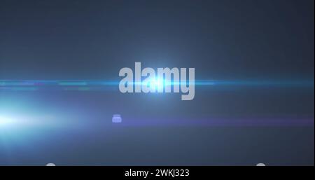Bild eines blauen Spots mit Lichtreflexlicht und Lichtstrahlen, die sich über dunklem Hintergrund bewegen Stockfoto