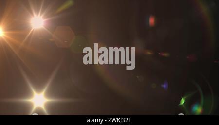 Bild eines Scheinwerfers mit Streulicht und Lichtstrahlen, die sich über einen dunklen Hintergrund bewegen Stockfoto