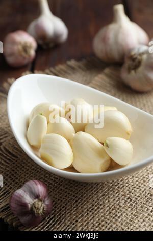 Frische Knoblauchzehen und Zwiebeln auf dem Tisch, Nahaufnahme Stockfoto