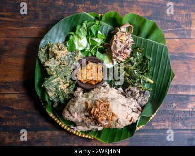 Ingkung Ayam, ein traditionelles Essen aus Yogyakarta, Indonesien, hergestellt aus einem ganzen Huhn, gekocht mit Gewürzen, Gemüse und Kokosmilch. Stockfoto