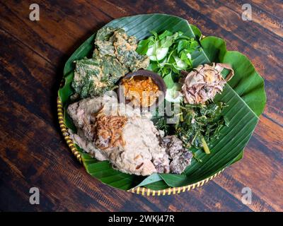 Ingkung Ayam, ein traditionelles Essen aus Yogyakarta, Indonesien, hergestellt aus einem ganzen Huhn, gekocht mit Gewürzen, Gemüse und Kokosmilch. Stockfoto