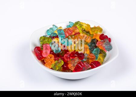 Bunte Gummibären ausgewählte Aromen in der weißen Schüssel auf weißem Hintergrund. Seitenansicht. Stockfoto