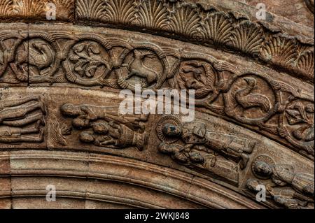 Szenen aus dem Leben des Apostels Paulus, darunter eine Taufe (links unten), die in einem Archivolt über dem Eingang zur Basilika des Klosters Santa Maria de Ripoll in der Provinz Girona, Katalonien, Spanien, gemeißelt wurde. Der Eingang wurde Mitte der 1100er Jahre im lombardischen romanischen Stil gestaltet. Im Archivolt über St. Paul sind ein Hirsch, ein Vogel und andere Tier- und Pflanzenmotive zu sehen. Stockfoto