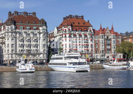 Historische Gebäude am Strandvagen 7 sind das Hotel Esplanade (l) und das Hotel Diplomat (r) hinter Booten und Fähren in Nybroviken, Ostermalm, Stockholm Stockfoto