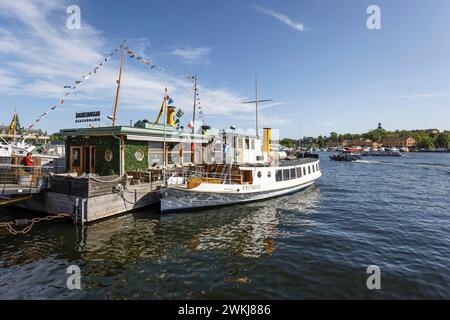 Touristenboot an der historischen Strandvagen Uferpromenade an Cafés, Bars und Booten im Ladugårdslandsviken See, Ostermalm, Stockholm Stockfoto