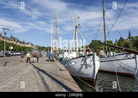 Auf der historischen Strandvagen-Uferpromenade spazieren die Menschen an Cafés, Bars und Booten im Ladugårdslandsviken-See, Ostermalm, Stockholm Stockfoto