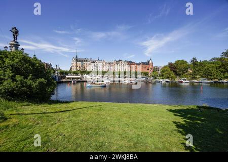 Boote, die an der Strandvägen-Kai-Promenade auf dem historischen, baumbestandenen Boulevard vor Anker liegen, an Gebäuden in Bajonetten-Gegend in Ostermalm, Stockholm. Stockfoto