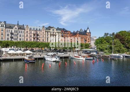 Boote, die an der Strandvägen-Kai-Promenade auf dem historischen, baumbestandenen Boulevard vor Anker liegen, an Gebäuden in Bajonetten-Gegend in Ostermalm, Stockholm. Stockfoto