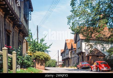 Historische Fachwerkgebäude Red VW Käfer Volkswagen Car in Street, Stoke by Nayland, Suffolk, England, Juli 1976 Stockfoto